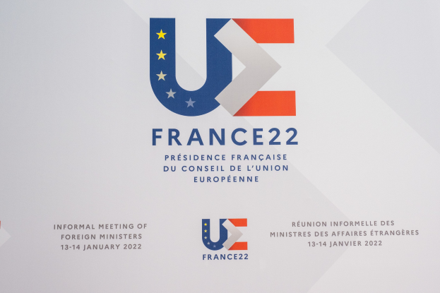 Plakat für die "Frankreich 22 - Informelle Tagung der Außenminister" mit dem Logo der Europäischen Union, das einen blauen Kreis mit einem weißen Stern und schwarzen Text in der Mitte zeigt.