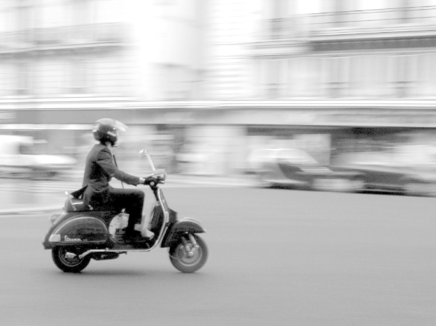 Eine Person fährt mit einem Scooter auf der Straße.