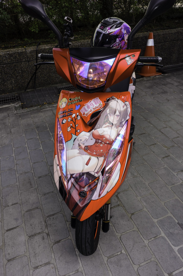 Ein oranger E-Scooter mit Helm daneben auf der Straße geparkt, mit einer Verkehrskegel, einer Wand und Bäumen im Hintergrund.