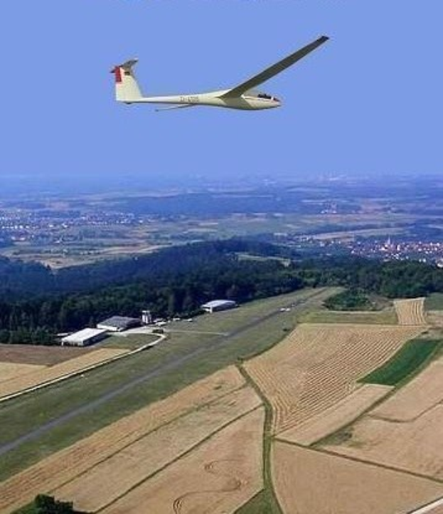 Segelflug über einem Feld mit Bäumen und Gebäuden im Hintergrund, mit Text oben auf dem Bild.