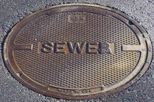 Metall-Schachtrinne auf der Straße mit der eingravierten Aufschrift "Kanal"