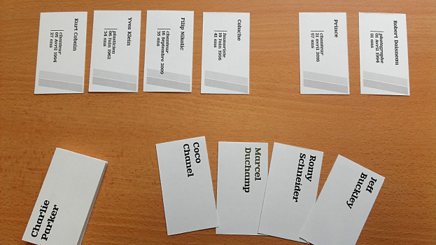 Ein Holztisch mit mehreren weißen Visitenkarten.