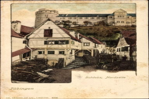 Eine alte Postkarte, die ein Gebäude mit einem Turm im Hintergrund zeigt, umgeben von Bäumen unter einem klaren blauen Himmel, mit dem Text "Tübingen, Deutschland" unten.