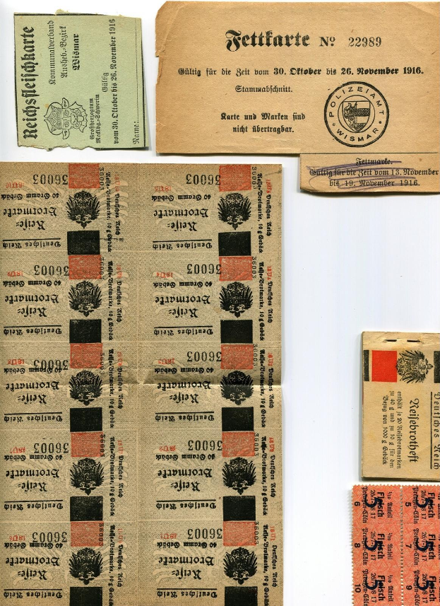 Sammlung von abgenutzten, alten deutschen Fahrkarten und Marken auf einem weißen Hintergrund, mit gedrucktem Text und Zahlen.