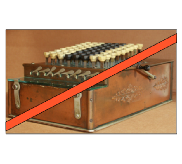 Eine altmodische Kasse mit einem roten Kreuz darüber, die einige Knöpfe und ein rotes Band hat, steht auf einem Tisch.