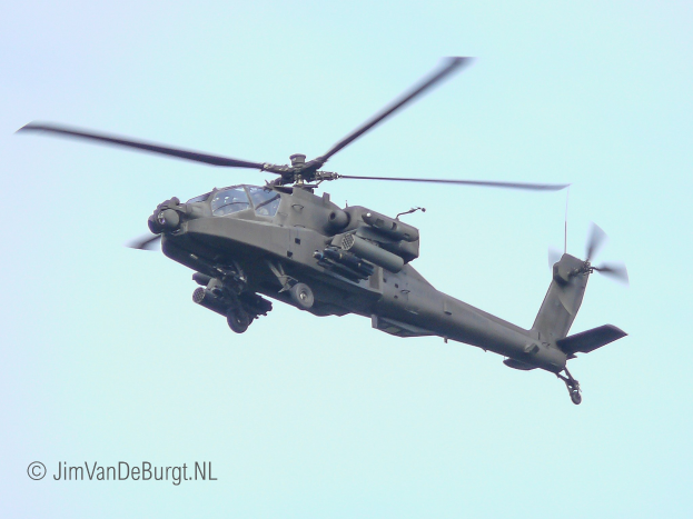 Ein militärisches Chinook-Hubschrauber fliegt mit ausgefahrenem Fahrwerk, seine beiden Rotoren drehen sich schnell gegen einen klaren Himmel.