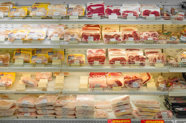 Ein gut organisierter Supermarktboden mit verschiedenen Arten von sauber angeordnetem Fleisch mit sichtbaren Preisschildern.