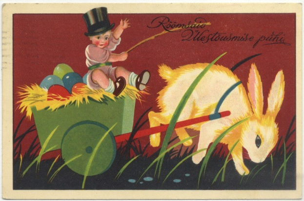 Alte Postkarte mit einem Baby in einem Zylinder, das einen Karren voller bunter Ostereier schiebt, begleitet von einem Kaninchen und einer handgeschriebenen Ostergrüß.