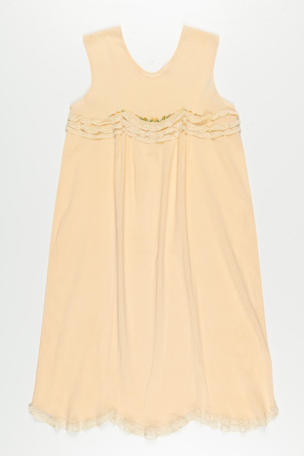 Ein cremefarbenes Nachthemd mit zartem Spitzenbesatz am Halsausschnitt, gefertigt aus weichem, leichtem Stoff mit einem dezenten Schimmer.