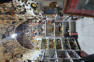 Ein überfülltes Souvenir-Shop-Interieur mit verschiedenen Artikeln in Schränken, von der Decke hängend und einem Teppich auf dem Boden.