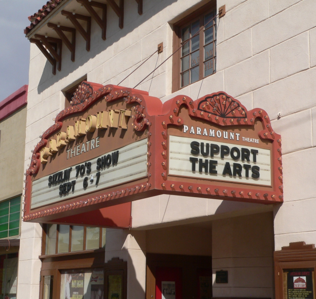 Außenansicht des Paramount Theatre in Sacramento, Kalifornien, mit Glasfenstern und -türen sowie einer "Support the Arts"-Schrifttafel und einem sichtbaren Himmel im Hintergrund.
