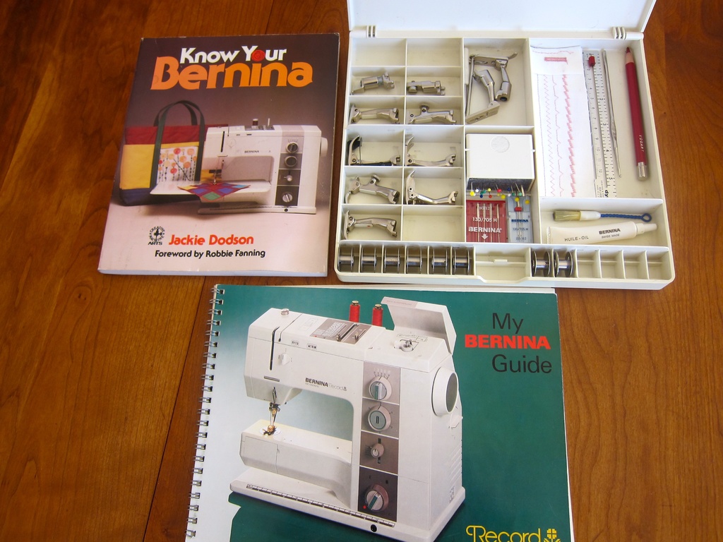 Two books and an open toolbox with tools inside are placed on a table.