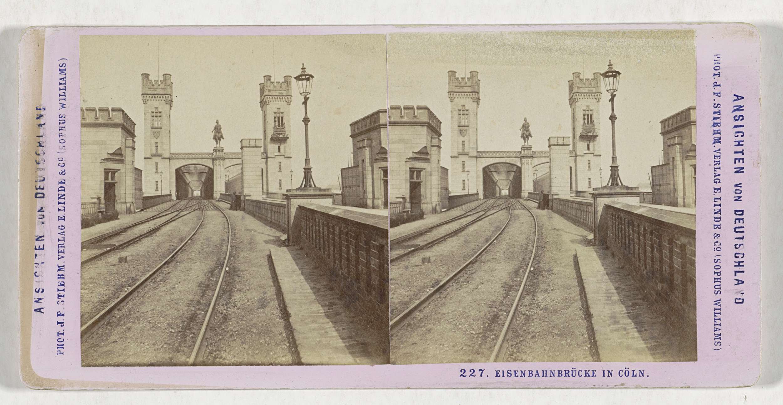 Schwarz-weißes stereoskopisches Foto einer Eisenbahnbrücke in Köln, Deutschland, mit Eisenbahnschienen, Wänden, Pfählen, Statuen und Text.
