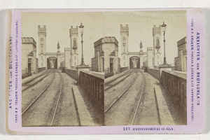 Schwarz-weißes stereoskopisches Foto einer Eisenbahnbrücke in Köln, Deutschland, mit Eisenbahnschienen, Wänden, Pfählen, Statuen und Text.